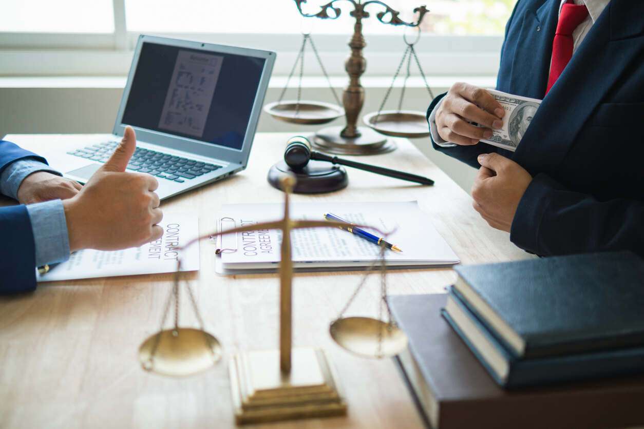 Work compensation attorney in Santa Monica Lawyer is sitting on the table with laptop and gavel infornt of client .