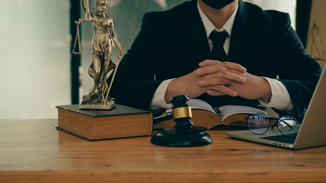 Lawyer is sitting on the table with gavel and laptop