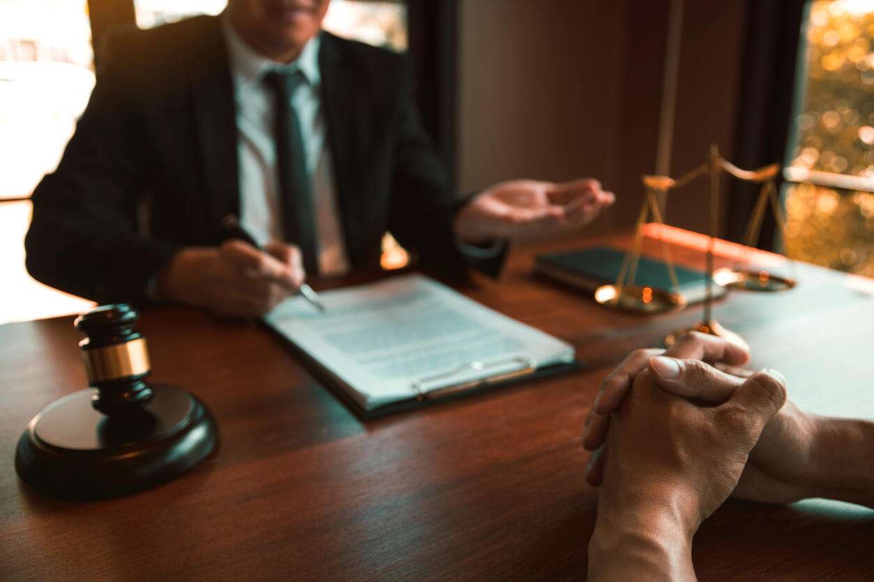 workers' compensation attorney in Beverly Hills lawyer is sitting on the table with gavel infront of client
