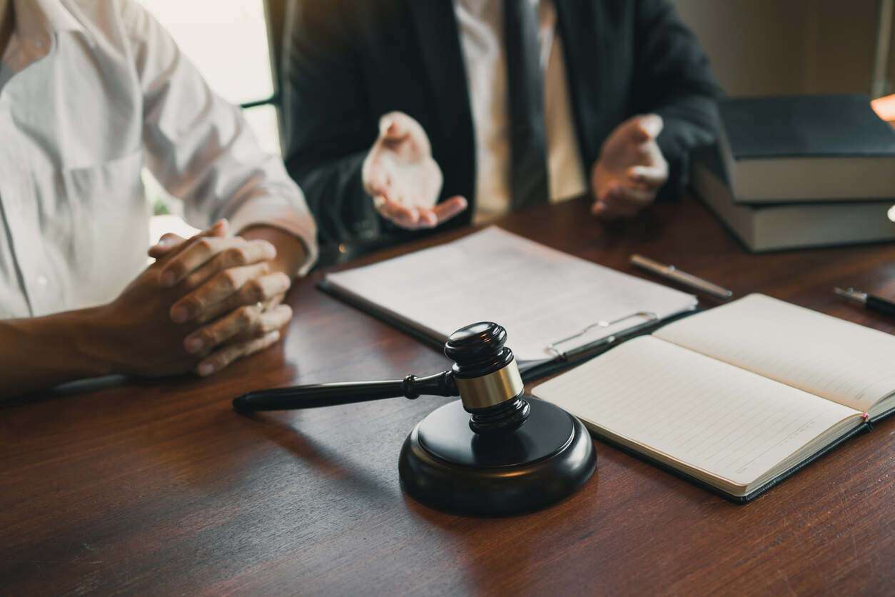 El Monte personal injury lawyer client and personal injury lawyer discussing the injury cliam and gavel on the table