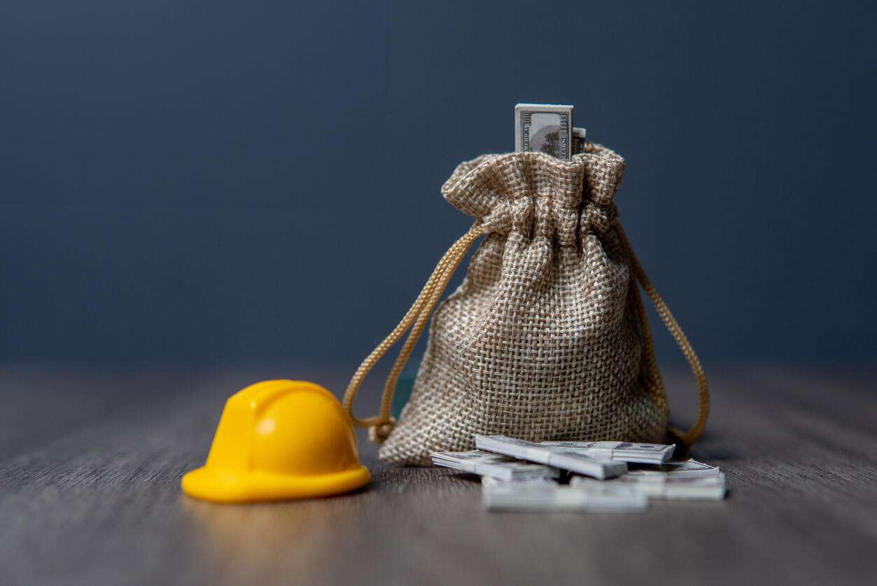 encino worker comp worker comp money and a hard hat on a wooden table