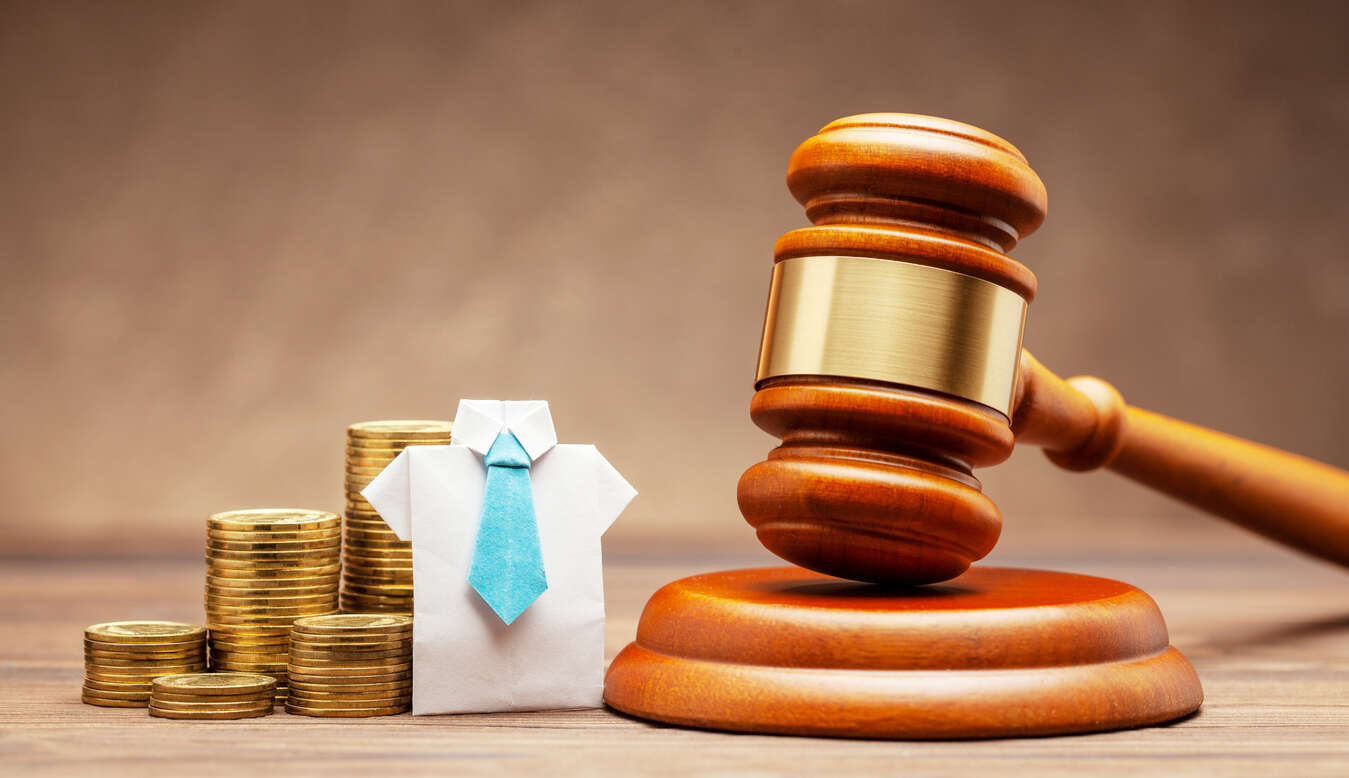 Riverside Workers compensation lawyer Gavel, stacks of coins, and an origami shirt with a tie, symbolizing legal compensation and justice.