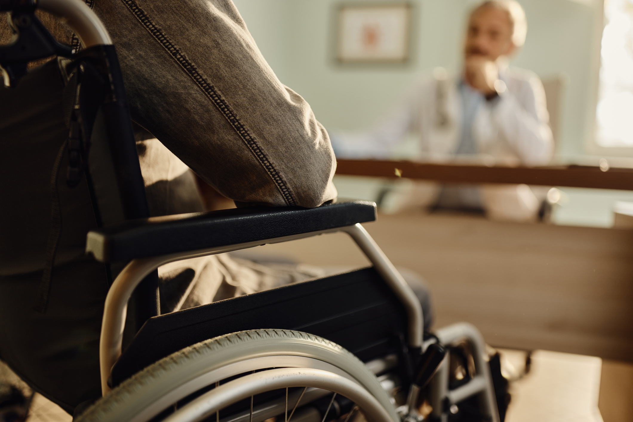 Person in a wheelchair meeting with a doctor or legal professional, representing a consultation with a permanent disability lawyer.