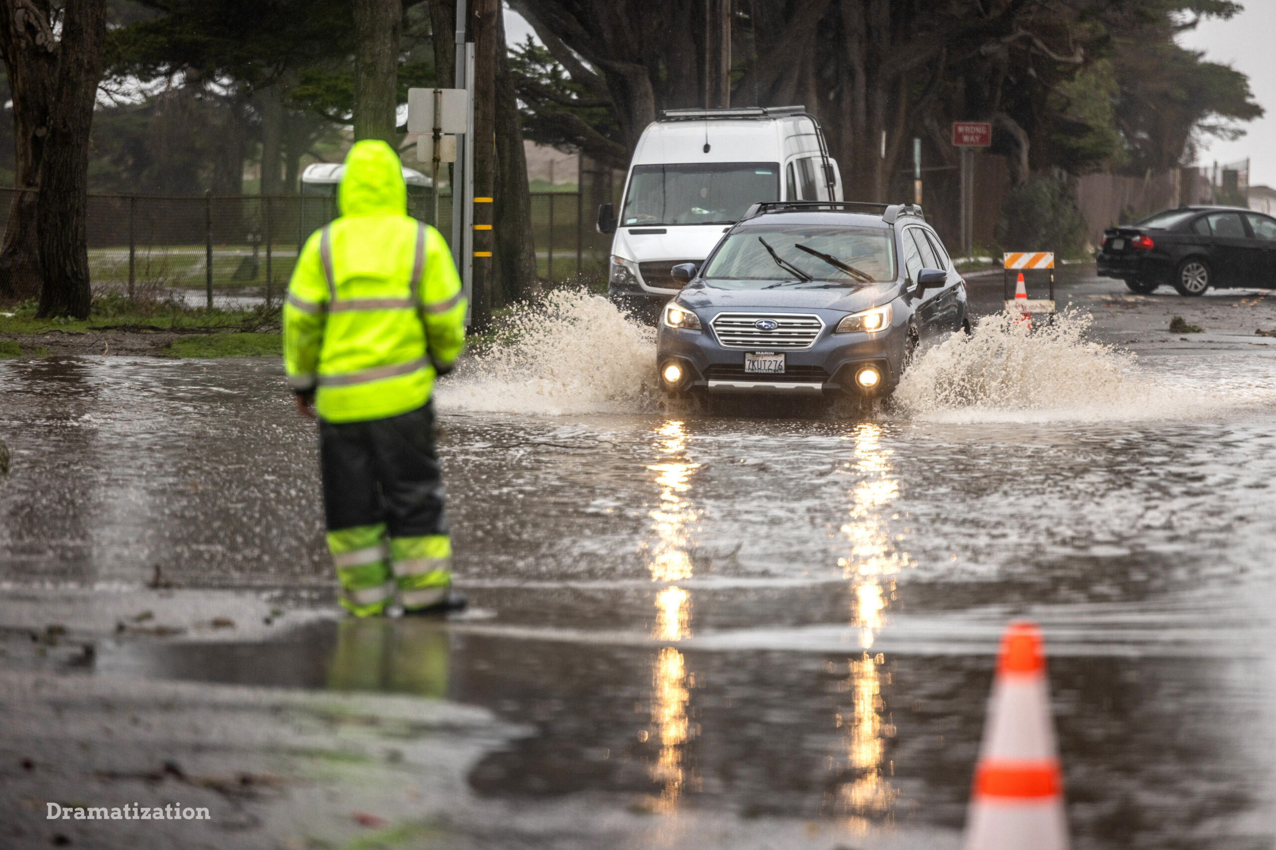 A worker organizing traffic in a flooded street